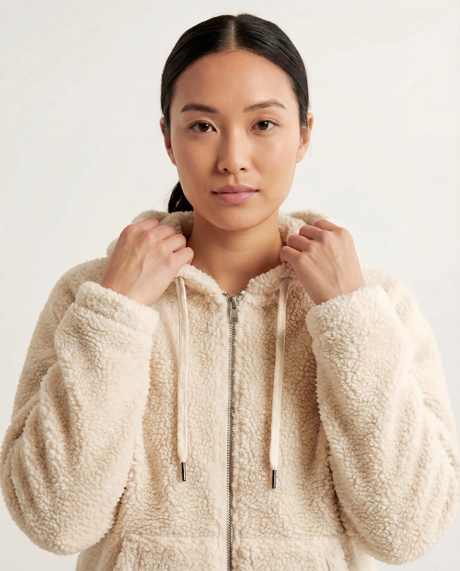 Immagine e-commerce con modella che indossa felpa teddy beige su sfondo neutro