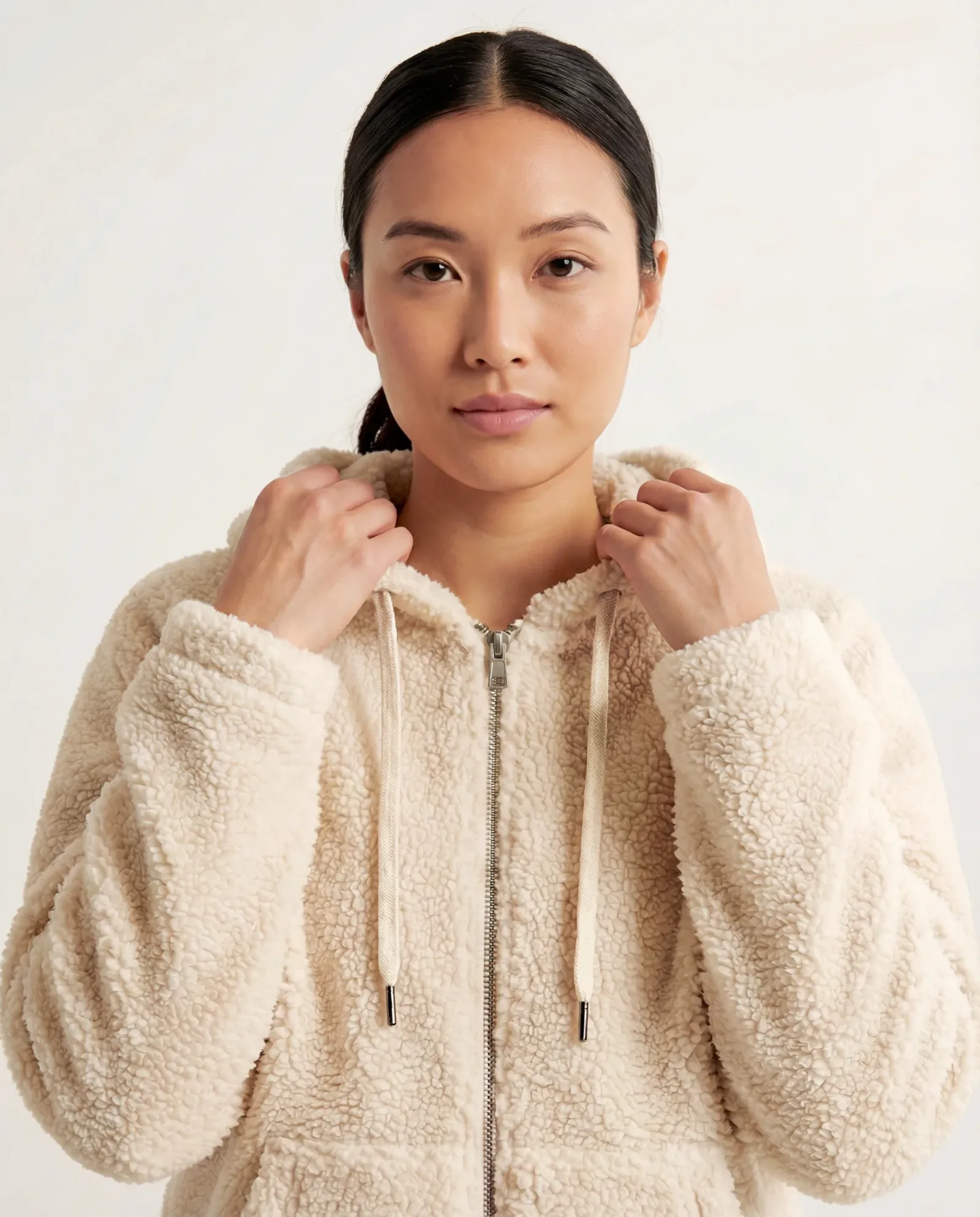 Immagine e-commerce con modella che indossa felpa teddy beige su sfondo neutro