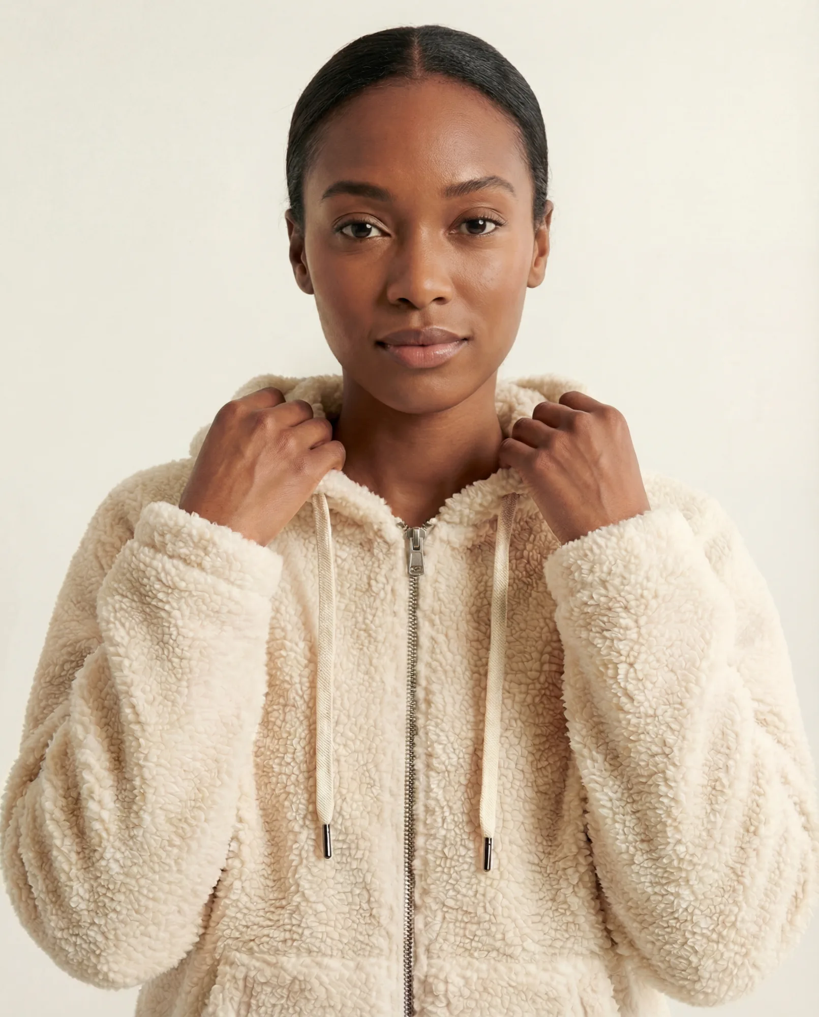 Felpa teddy beige su modella differente per catalogo e-commerce su sfondo neutro