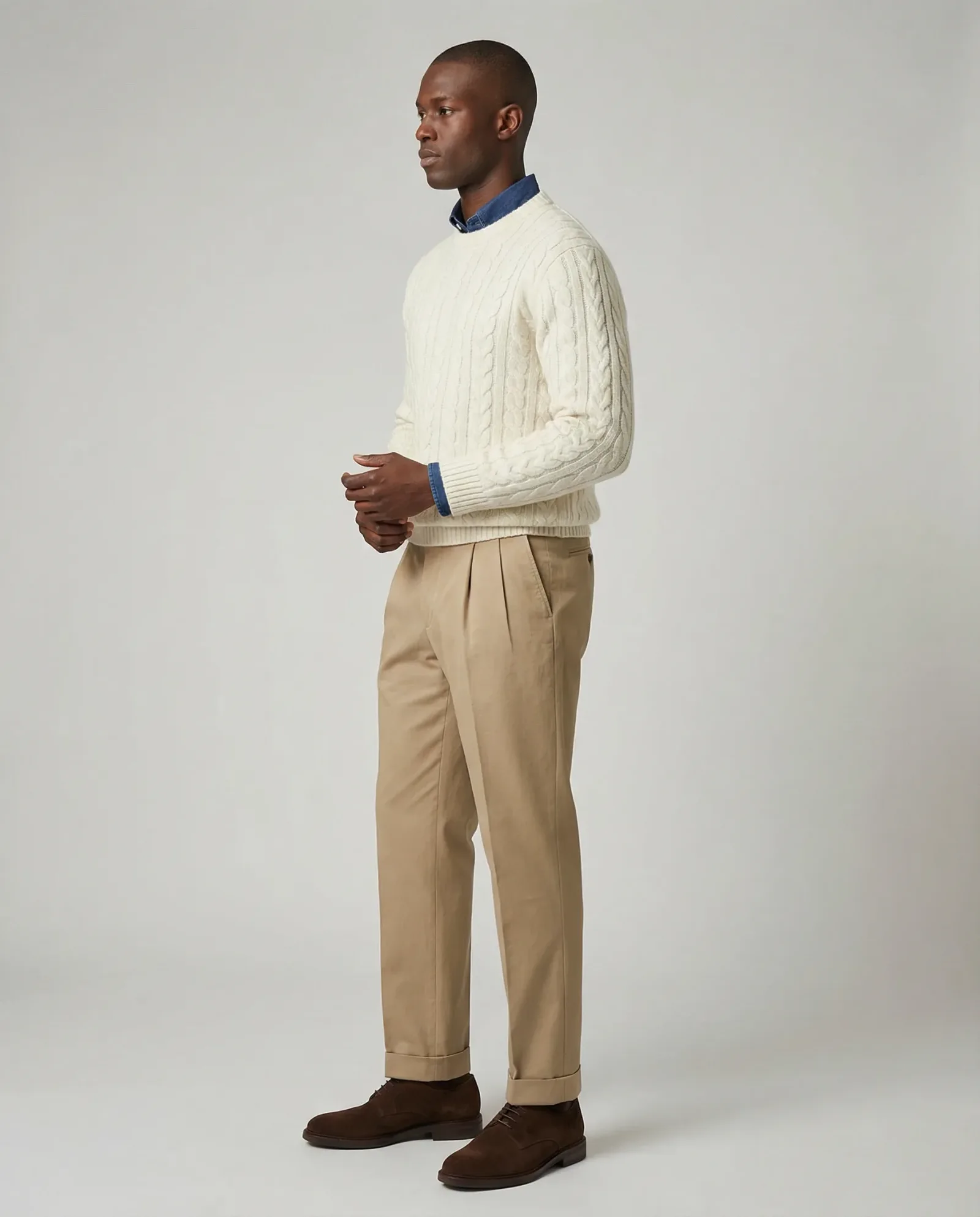 Immagine e-commerce menswear con modello in maglione chiaro e pantaloni beige su sfondo neutro