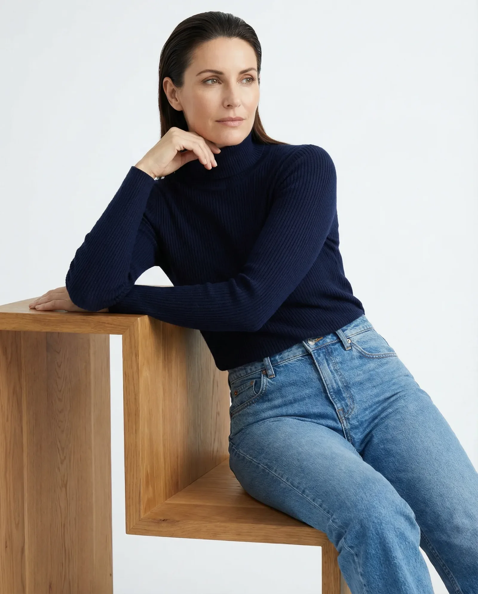 Immagine e-commerce con modella in maglia blu e jeans su sfondo neutro