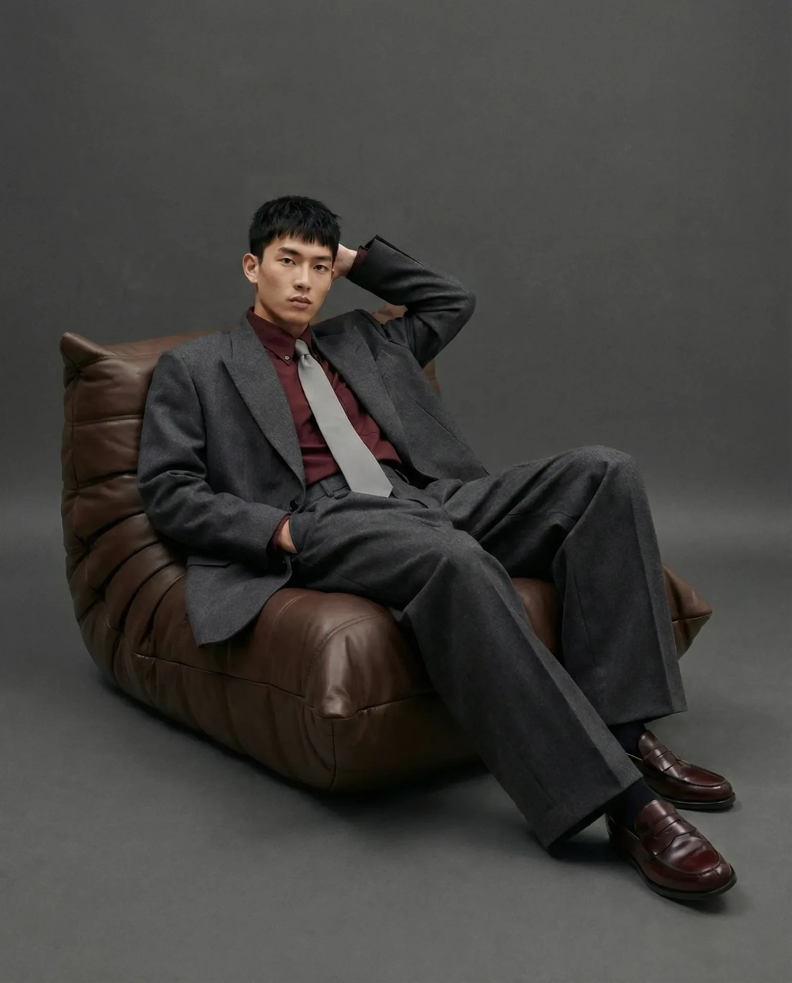 Immagine e-commerce menswear generata con AI con modello in completo elegante su sfondo scuro editoriale