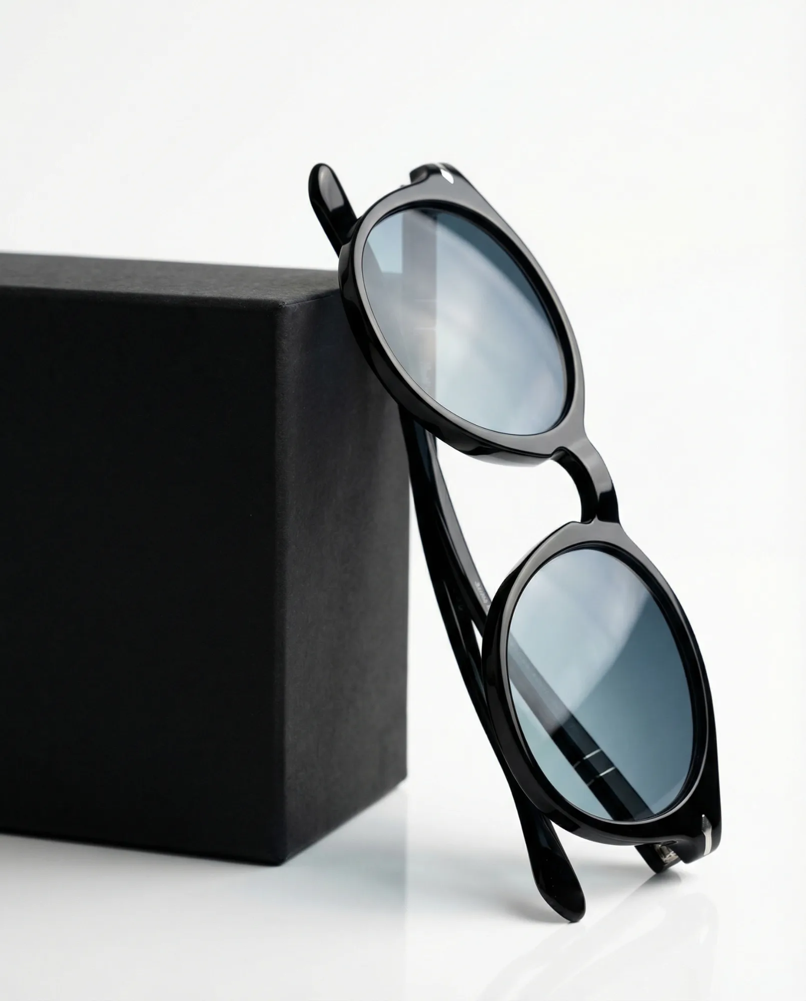 Composizione di occhiali da sole su superficie riflettente con luce calda e fredda, fotografia prodotto eyewear lifestyle