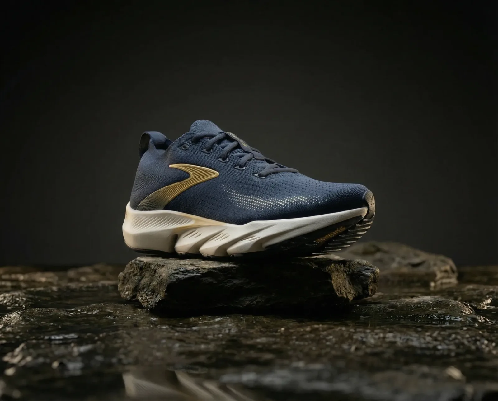 Sneaker sportiva blu con dettagli dorati appoggiata su roccia con illuminazione drammatica.